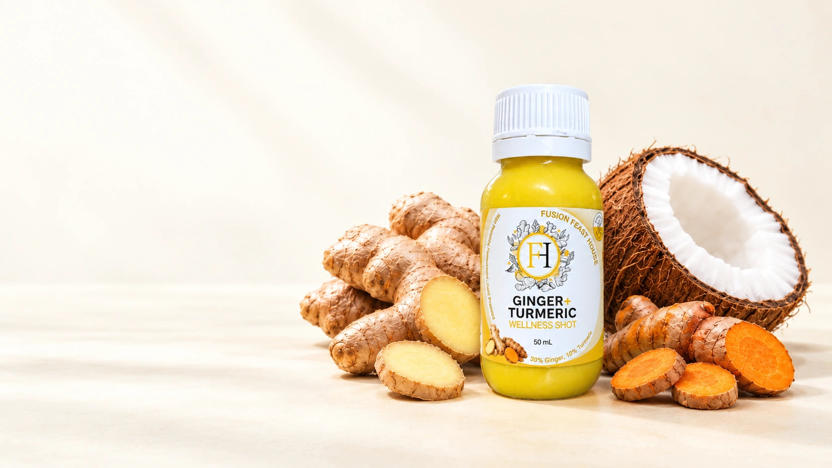 Fusion Feast House ginger and turmeric shot with a white cap, beside ginger, turmeric and coconut